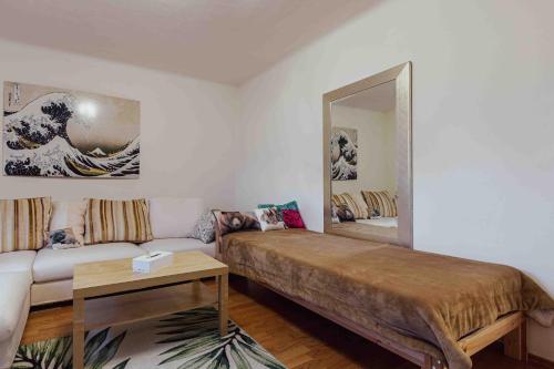 Zimmer mit einem Bett, einem Spiegel und einem Sofa in der Unterkunft Benjamins Refugium in Salzburg