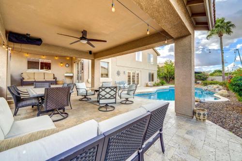 a patio with a table and chairs and a pool at Peoria Vacation Rental with Pool and Hot Tub! in Peoria
