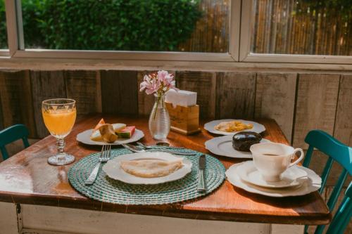 una mesa con platos de comida y un jarrón de flores en Pousada Sette Mares en Fernando de Noronha