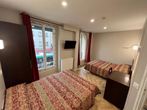 a hotel room with two beds and a window at Hipotel Paris Printania Maraichers in Paris