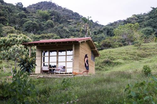 a small house on a hill with a person standing outside at Camelia Hostel in San Carlos