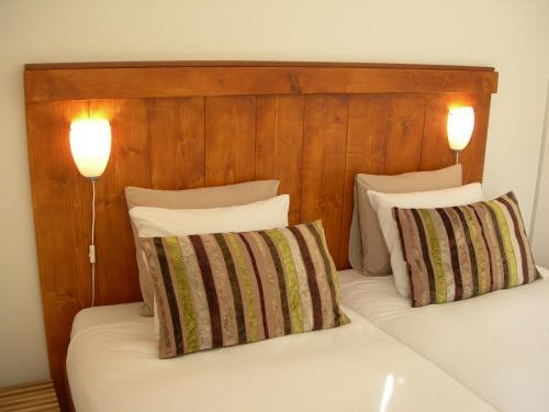 a bed with two pillows and two lights on it at Pension Kamperland in Kamperland