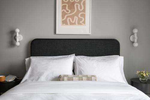 a bedroom with a white bed with a black headboard at Mint House Birmingham - Downtown in Birmingham