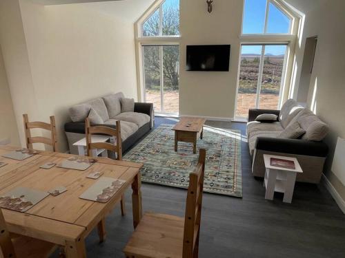 a living room with a couch and a table at Remote Wilderness - sleeps 4 to 6 in Halkirk