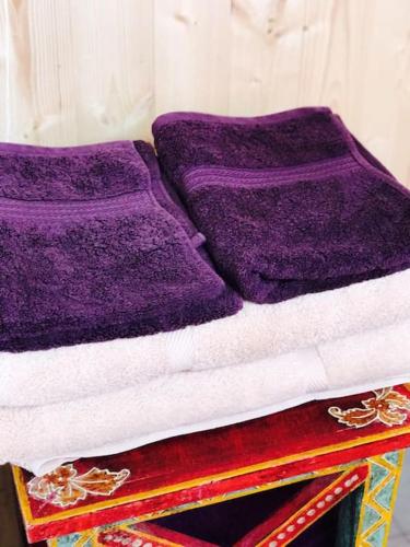 a bed with purple sheets on top of a table at Cosy Private Cabin with parking in good location in Oxford