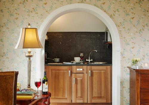 an archway leading to a kitchen with a sink at Red Cliff Lodge in Spanish Point