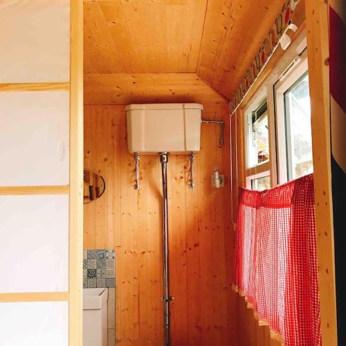 a small room with a window and a red net at Cosy Private Cabin with parking in good location in Oxford