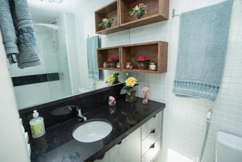 uma casa de banho com um lavatório e um espelho em Studio Smart Farol da Barra Completo e Funcional em Salvador