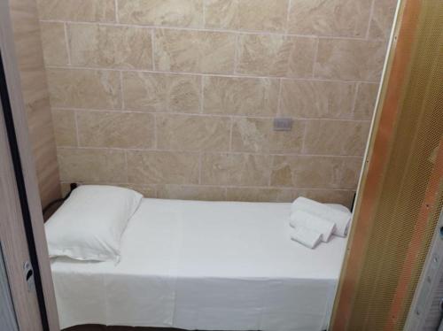 サンタ・マリア・アル・バーニョにあるCasa Perlaのベッド1台とタオル2枚が備わる小さな客室です。