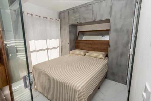 um pequeno quarto com uma cama e um espelho em Studio Smart Farol da Barra Completo e Funcional em Salvador