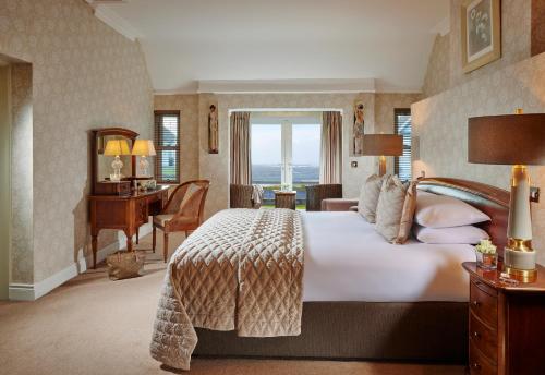 a bedroom with a bed and a desk in a room at Red Cliff Lodge in Spanish Point