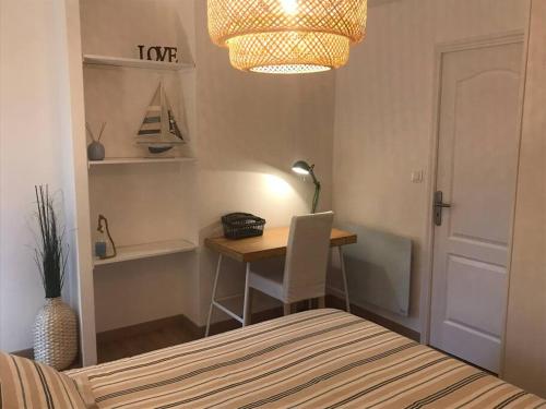 a bedroom with a bed and a desk with a lamp at Winnipeg in Colombiers-sur-Seulles