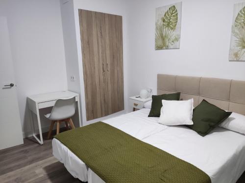ein Schlafzimmer mit einem großen Bett mit grünen und weißen Kissen in der Unterkunft Rucanon 2 La casa del campo 4 Estrellas in Montánchez