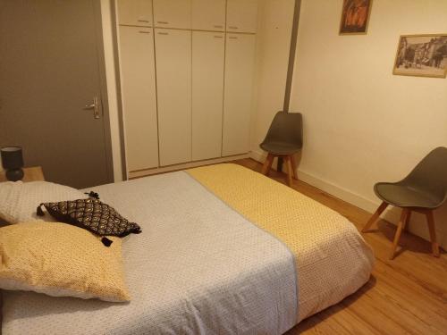 1 dormitorio con 1 cama y 2 sillas en Aux Thermes en Salins-les-Bains