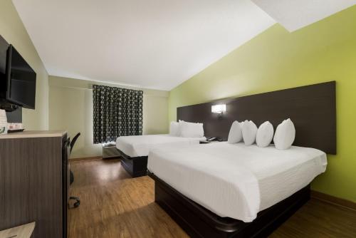 コロンバスにあるSureStay Hotel by Best Western Columbus Downtownのベッド2台、薄型テレビが備わるホテルルームです。