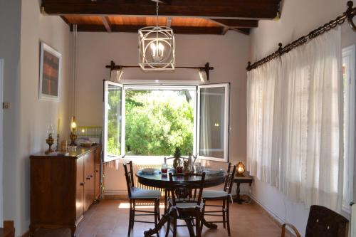 comedor con mesa, sillas y ventana en Villa “Serenity”, en Agios Leon