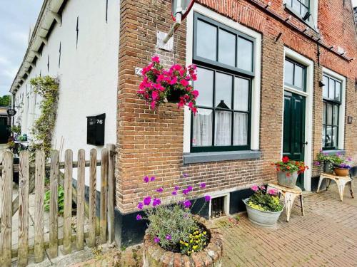a brick building with a window with flowers on it at De Scheve Deur in Vollenhove