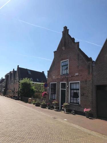 a brick building on a cobblestone street at De Scheve Deur in Vollenhove