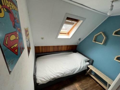 a small bed in a small room with a window at De Scheve Deur in Vollenhove