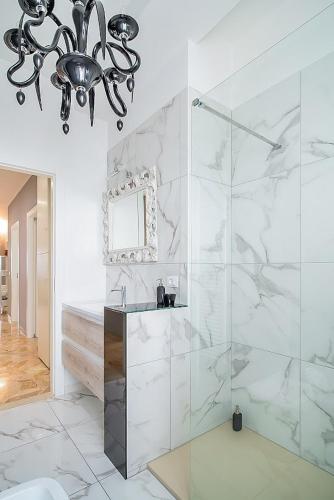 a bathroom with a shower and a sink and a chandelier at Elegant & Spacious - 30 min from Venice - King beds! in Treviso