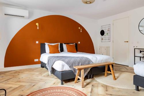 a bedroom with a large bed with an orange headboard at Boetiek hotel Azul in Goedereede