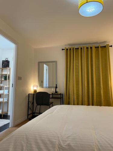 a bedroom with a bed and a desk and a window at Large Comfortable Bed with Own Bathroom Free Parking and Wifi in West Thurrock Grays in Grays Thurrock
