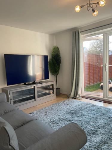 a living room with a flat screen tv and a couch at Large Comfortable Bed with Own Bathroom Free Parking and Wifi in West Thurrock Grays in Grays Thurrock