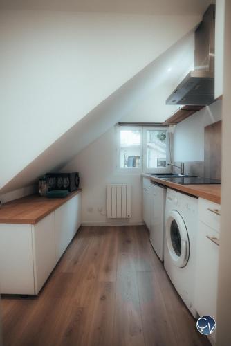 une cuisine avec des armoires blanches et une laveuse et une sécheuse dans l'établissement Charmant studio rénové - Proche centre ville, à Nîmes