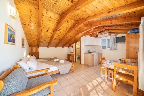 a large room with a bed and a dining room at Alexatos Studios & Apartments in Ayia Evfimia