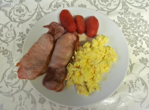 a plate of breakfast food with sausage and eggs at Fairlawns Guest House in Banbury