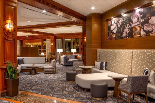 a hotel lobby with couches and tables and chairs at Sheraton Music City Nashville Airport in Nashville