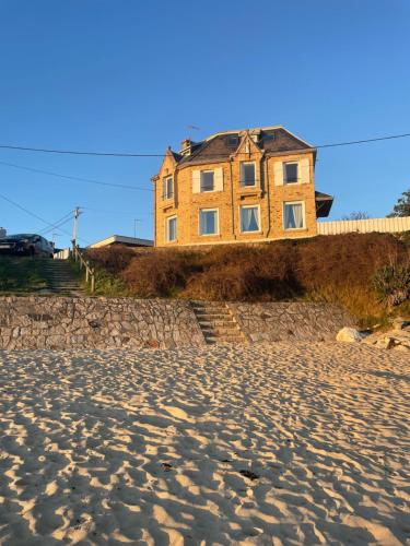 a house on the beach next to the sand at Villa Sainte-Anne - Ploemeur in Ploemeur