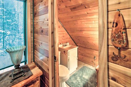 a bathroom with a toilet in a wooden cabin at Iron River Cabin Rental with Fireplace and Deck! in Iron River