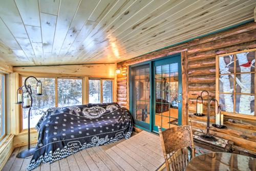 a bedroom in a log cabin with a bed and a table at Iron River Cabin Rental with Fireplace and Deck! in Iron River