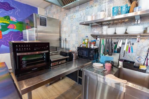 una cucina con piano cottura e bancone in acciaio inossidabile di Hostelle - women only hostel London a Londra