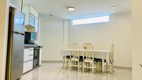 タクナにあるDepartamento Avenida Bolognesi Tacnaのキッチン(テーブル、椅子、冷蔵庫付)