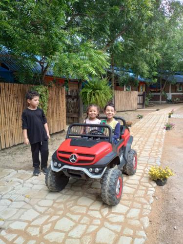 two children riding on a toy four wheeler at Finca Ecoturistica LOS JAGUEYES in Baraya