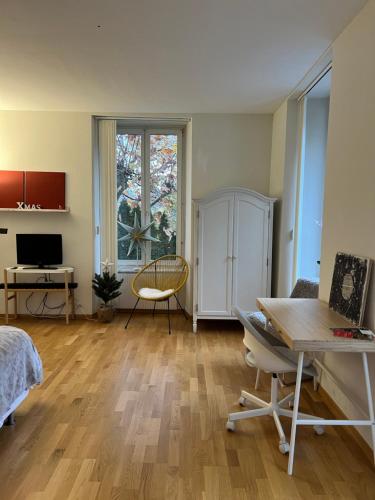 un soggiorno con tavolo e scrivania di Eigenes Studio (Apartment) a Biel