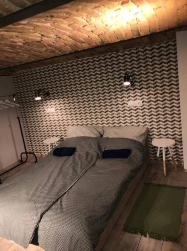 a bedroom with a bed and a brick wall at Csengery Apartment in Budapest