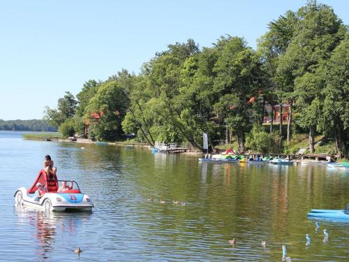 a woman riding a pedal boat in a lake at Holiday Home in Kretowiny near Lake in Kretowiny