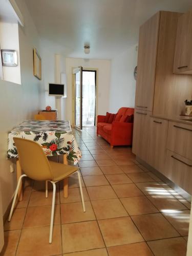 un salon avec une table et un canapé rouge dans l'établissement Les Glycines de Saint Bo, à Saint-Bonnet-en-Champsaur