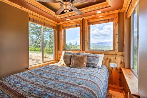 sypialnia z łóżkiem z oknami i wentylatorem sufitowym w obiekcie 28 Mi to Yosemite Lovely Mtn Cottage with Deck! w mieście North Fork