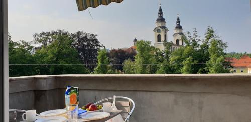 a table and chairs on a balcony with a building at Apartments Katrca Ljubljana in Ljubljana