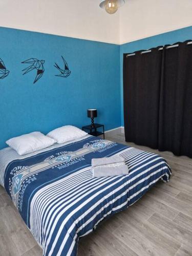 Schlafzimmer mit einem Bett mit blauer Wand in der Unterkunft Lou Gardian in Arles