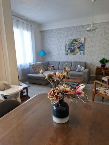 eine Vase mit Blumen auf einem Tisch im Wohnzimmer in der Unterkunft Lou Gardian in Arles