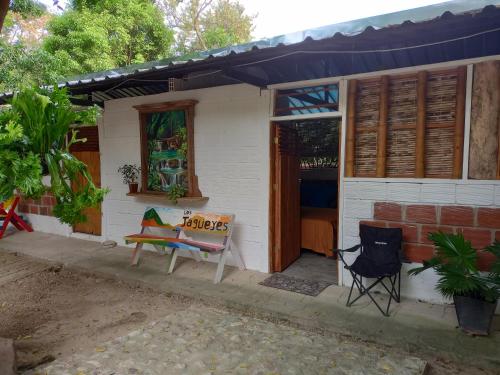 a white house with a table and chairs in front of it at Finca Ecoturistica LOS JAGUEYES in Baraya