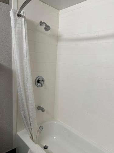 a bathroom with a shower with a white tub at Super 8 by Wyndham Clemmons - Bermuda Run - Winston-Salem I-40 in Clemmons