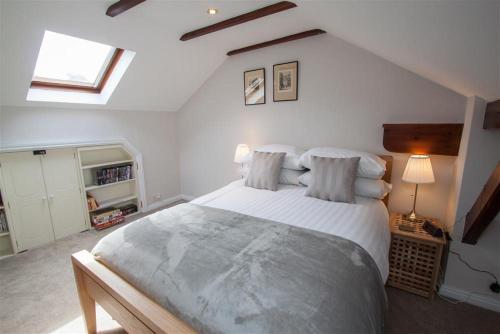 Old Stones Cottage في آمبيلسايد: غرفة نوم بسرير كبير في العلية