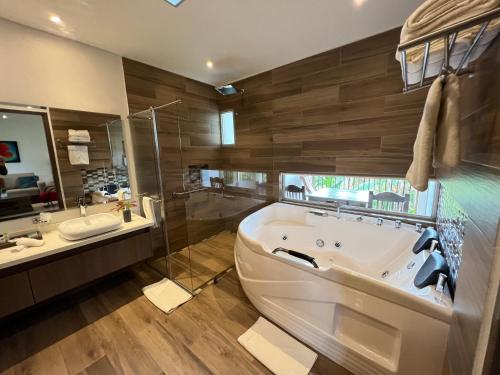 a large bathroom with a tub and a sink at Hotel Campestre Montecarlo in Montenegro