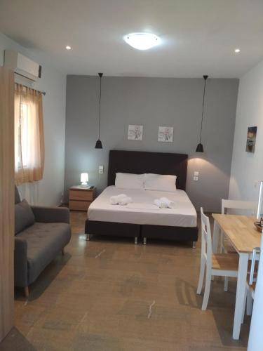 1 dormitorio con cama, sofá y mesa en Foinikas Apartment, en Mitikas